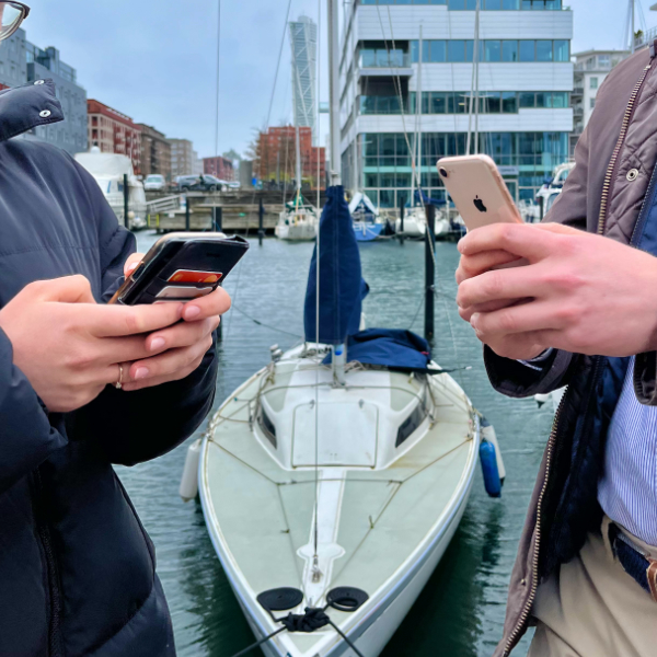 Nærbilde av to personer som bruker smarttelefonene sine, vendt mot hverandre