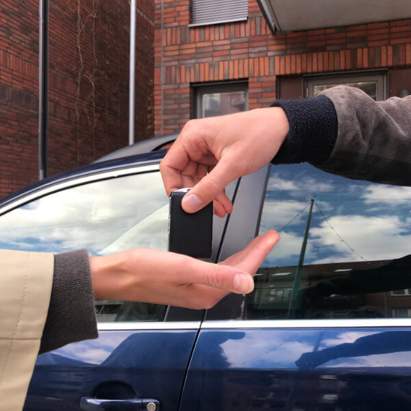 En person som överlämnar en bilnyckel till en annan person