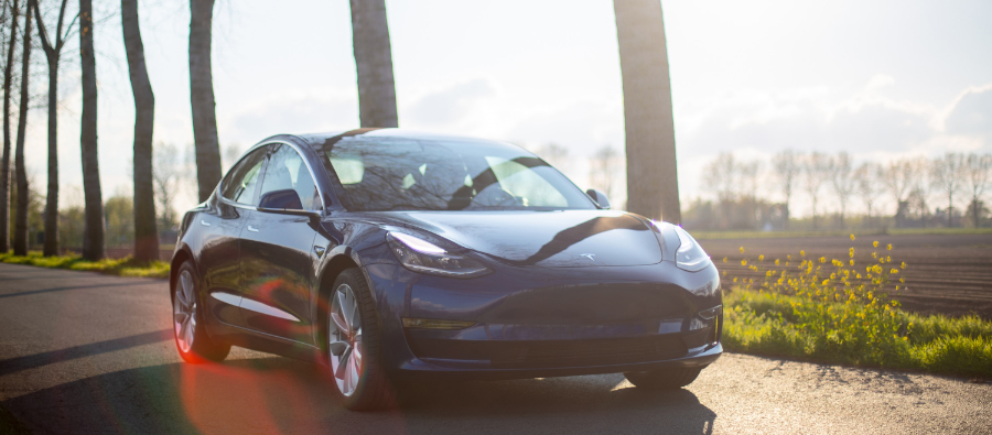 Blå Tesla körandes på landsväg