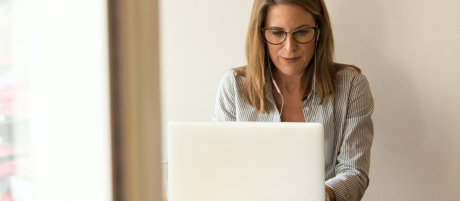 En kvinna med glasögon använder en bärbar dator